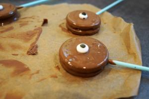 12) Die Oreo Kekse halbieren, Stiel einlegen und in Schokolade tunken