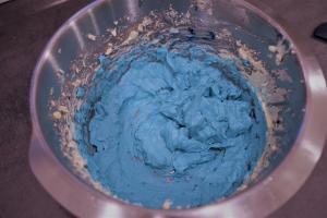 16) Restliche Buttercreme in 2 Portionen teilen, eine Hälfte in blau...