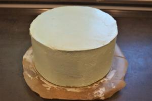 13) Die Torte komplett mit der Buttercreme einstreichen und glätten