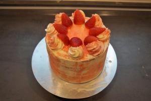 22) Oben auf der Torte Tupfer aufspritzen und mit Erdbeeren dekorieren