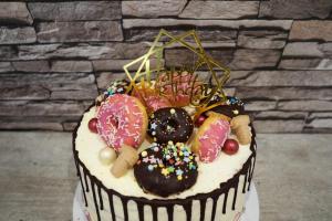 23) Die gesamte Torte mit Donuts, Keksen, Streusel und Topper dekorieren
