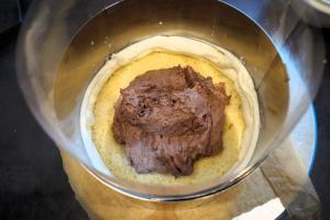 22) Obere Torte: 1. Biskuit auf einem Cakeboard fixieren, Rand aus Buttercreme spritzen ...