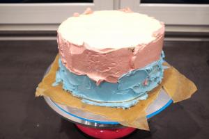 17) Die Buttercreme in rosa und blau färben und auf die Torte streichen