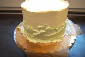 21) Etwas Buttercreme mint grün färben und unten auf die Torte streichen